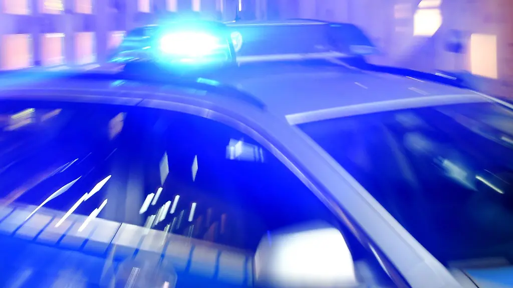 Ein-Streifenwagen-der-Polizei-steht-mit-eingeschaltetem-Blaulicht-auf-der-Strasse