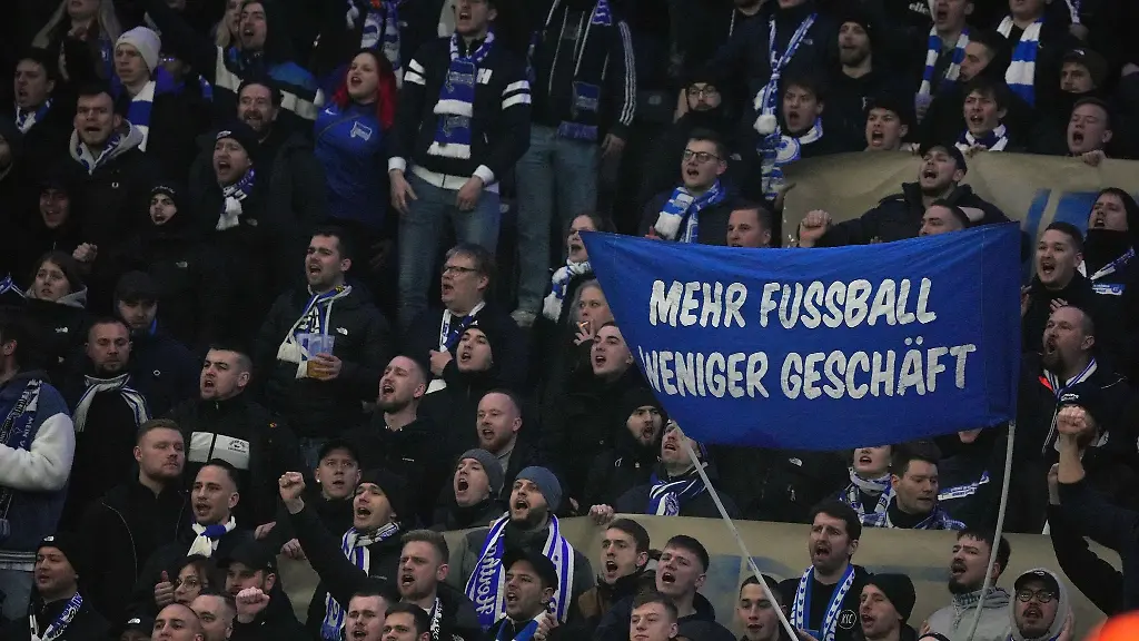 Hertha-Fans-zeigen-ein-Transparent-mit-der-Aufschrift-Mehr-Fussball-weniger-Geschaeft-Das-Spiel-gegen-den-HSV-war-wegen-eines-Protests-lange-unterbrochen