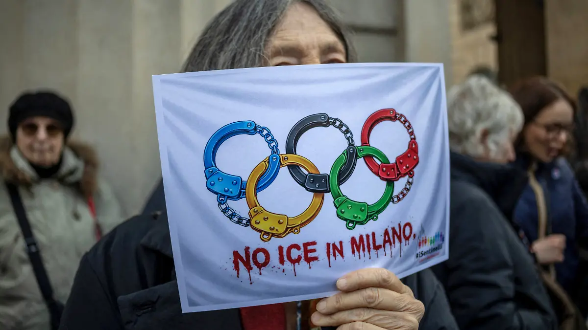 A-protester-holds-a-sheet-of-paper-with-a-printed-depiction-of-the-Olympic-rings-as-handcuffs-and-reading-No-ICE-in-Milano-during-a-demonstration-after-it-was-confirmed-that-U-S-Immigration-and-Customs-Enforcement-ICE-personnel-will-help-protect-U-S-delegations-at-the-Milan-Cortina-2026-Winter-Olympics-in-Milan-Italy-January-31-2026