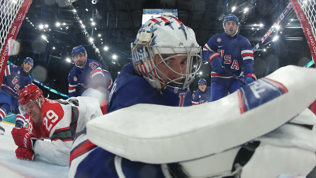 United-States-goalkeeper-Jeremy-Swayman-dives-to-makes-a-save-as-Denmark-s-Nick-Olesen-scores-his-side-s-opening-goal-during-a-preliminary-round-game-of-men-s-ice-hockey-between-the-United-States-and-Denmark-at-the-2026-Winter-Olympics-in-Milan-Italy-Saturday-Feb-14-2026