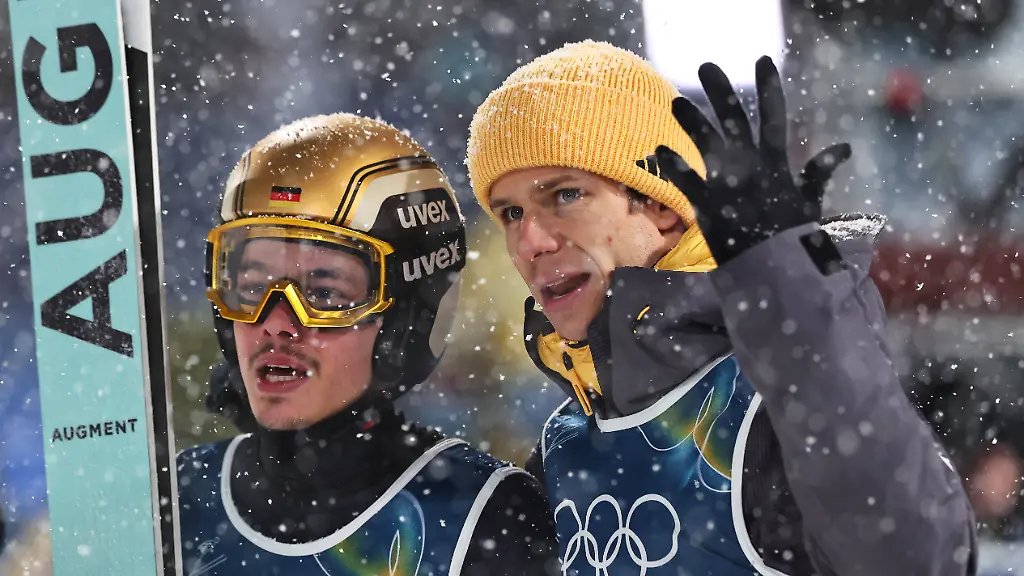 Olympia-Olympische-Winterspiele-Mailand-Cortina-2026-Ski-nordisch-Skispringen-Super-Team-Maenner-Finaldurchgang-Philipp-Raimund-l-Deutschland-reagiert-nach-seinem-Sprung-neben-Teamkollege-Andreas-Wellinger-Deutschland