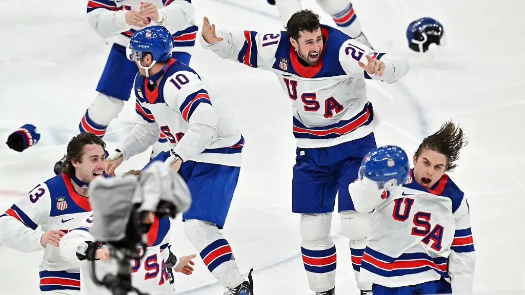 Olympia-Olympische-Winterspiele-Mailand-Cortina-2026-Eishockey-Maenner-Kanada-USA-Finalrunde-Finale-Jack-Hughes-vorne-r-USA-jubelt-mit-den-Teamkollegen-ueber-seinen-Siegtreffer