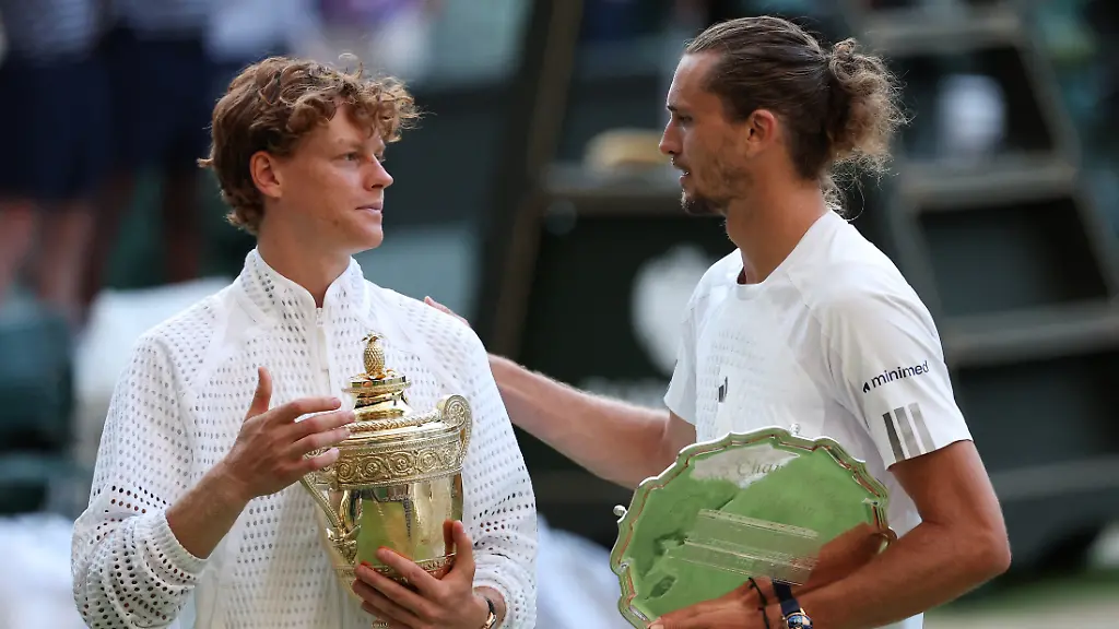 Tennis-Wimbledon-All-England-Lawn-Tennis-and-Croquet-Club-London-Britain-July-12-2026-Italy-s-Jannik-Sinner-celebrates-with-the-trophy-as-Germany-s-Alexander-Zverev-celebrates-with-the-runner-up-trophy-after-their-final-match-REUTERS-Toby-Melville
