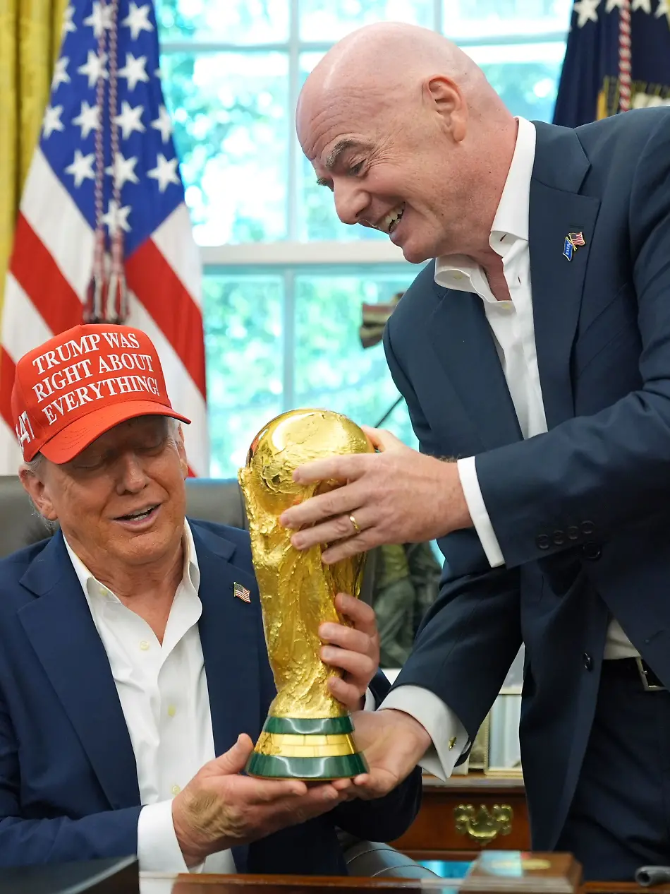 ARCHIV-22-08-2025-USA-Washington-FIFA-Praesident-Gianni-Infantino-r-ueberreicht-US-Praesident-Donald-Trump-die-FIFA-World-Cup-Winners-Trophy-waehrend-bei-einer-Ankuendigung-im-Oval-Office-des-Weissen-Hauses