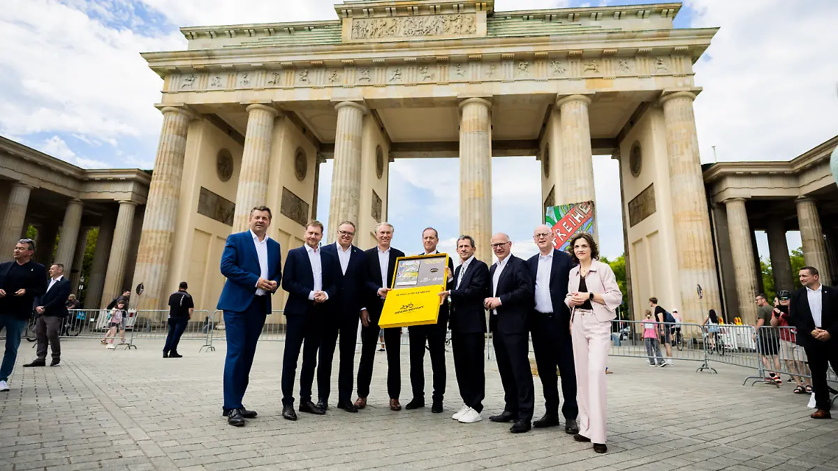 29-07-2026-Berlin-Radsport-Sven-Schulze-CDU-l-r-Ministerpraesident-von-Sachsen-Anhalt-Michael-Kretschmer-CDU-Ministerpraesident-von-Sachsen-Mario-Voigt-CDU-Ministerpraesident-von-Thueringen-Bernd-Dankowski-Praesident-des-deutschen-Radsportverbandes-German-Cycling-Christian-Prudhomme-Direktor-der-Tour-de-France-Yann-Le-Moenner-Geschaeftsfuehrer-A-S-O-Germany-Kai-Wegner-CDU-Regierender-Buergermeister-von-Berlin-Rudolf-Scharping-und-Elisabeth-Kaiser-Staatsministerin-und-Beauftragte-der-Bundesregierung-fuer-Ostdeutschland-stehen-bei-einem-Bildtermin-zur-Uebergabe-der-Bewerbung-um-den-Start-der-Tour-de-France-2029-in-Mitteldeutschland-an-den-Tourchef-Prudhomme-vor-dem-Brandenburger-Tor
