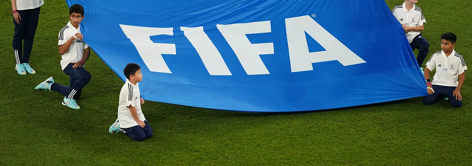 Fussball-WM-Frankreich-Daenemark-Vorrunde-Gruppe-D-Spieltag-2-Stadion-974-Kinder-halten-ein-Banner-mit-der-Aufschrift-FIFA-Der-Verband-entzieht-Indonesien-die-U20-WM